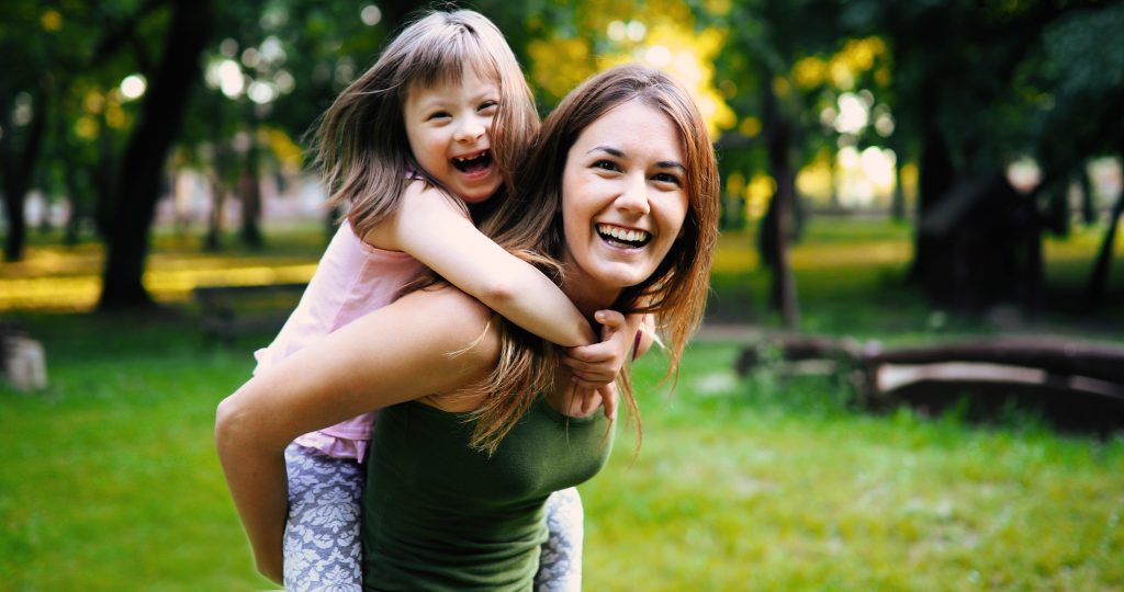 Woman smiling with a child on her back